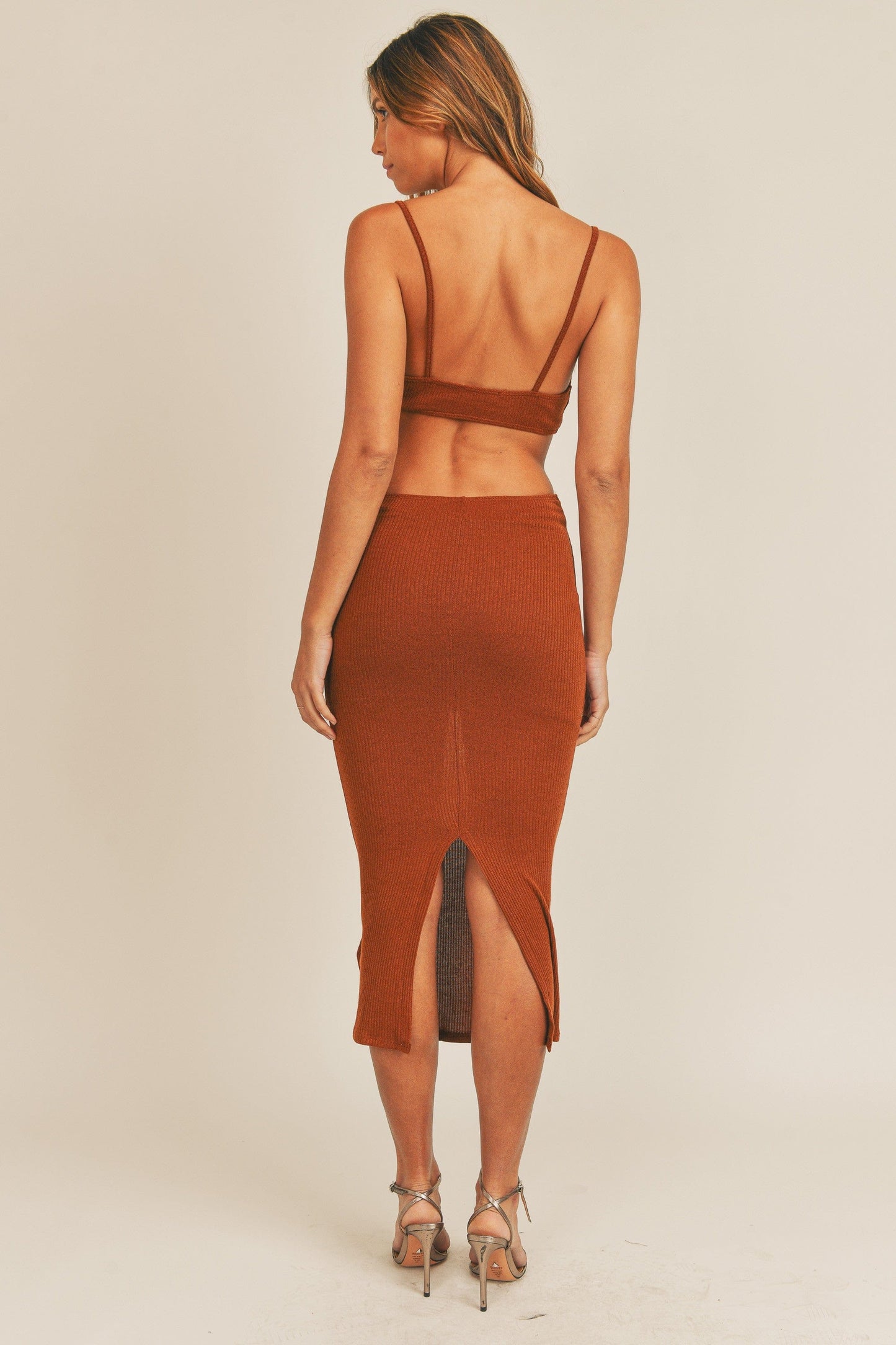 Sip Cognac-colored style with a daring midi cut, featuring a dramatic cut-out detail and a teasing back slit.