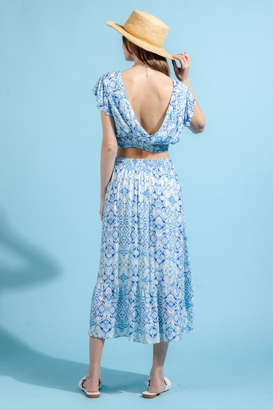 A model is wearing a blue and white skirt set. The top has a crop top and the skirt is midi length.