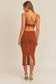  Sip Cognac-colored style with a daring midi cut, featuring a dramatic cut-out detail and a teasing back slit.