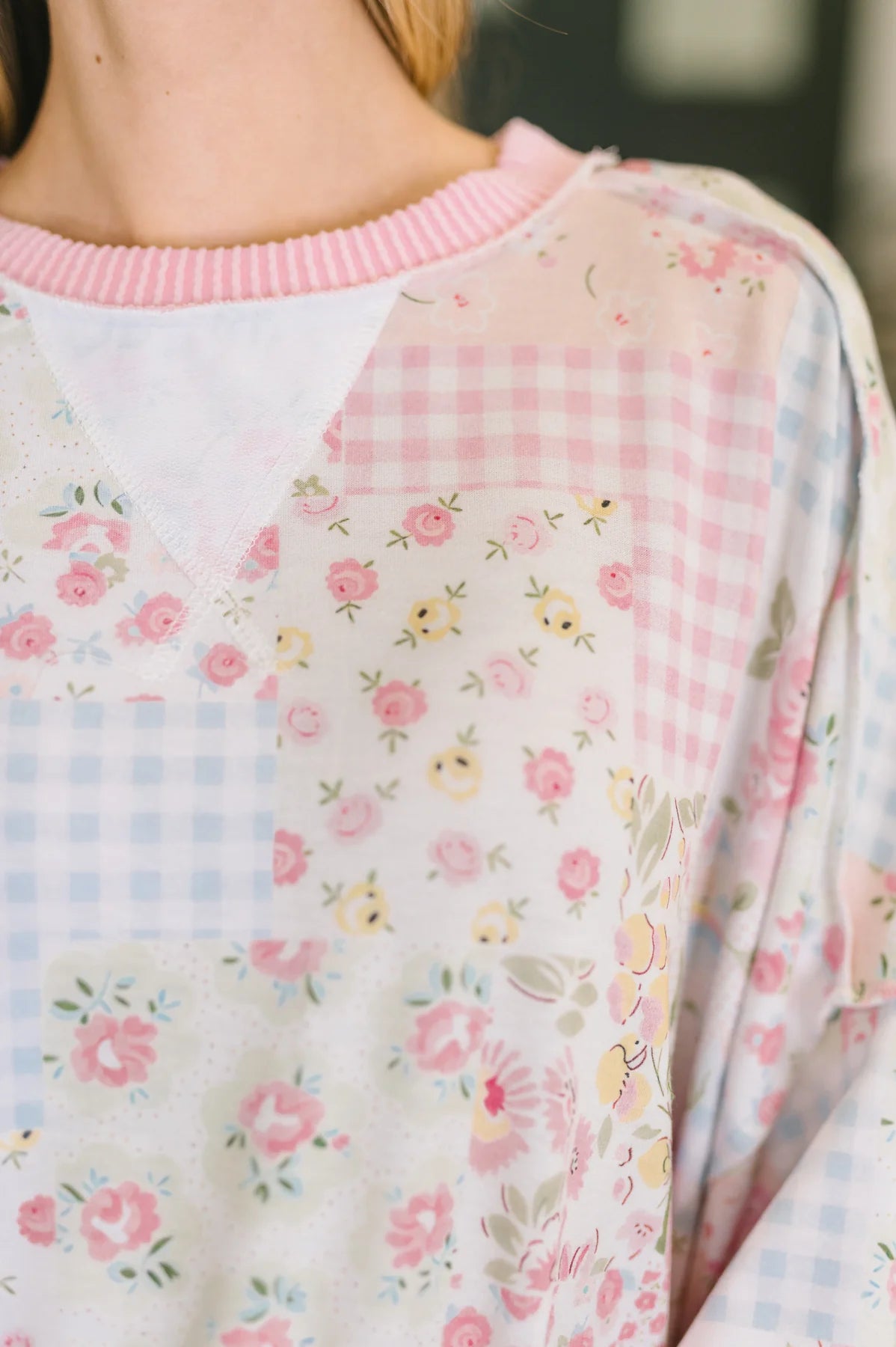 Close-up of a person wearing a floral-patterned outfit with a pink collar.