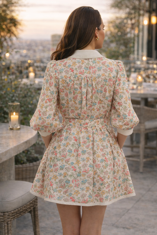 Woman wearing a floral dress standing outdoors with a scenic background