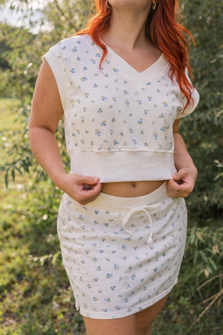 Person wearing a matching floral top and skirt set outdoors.