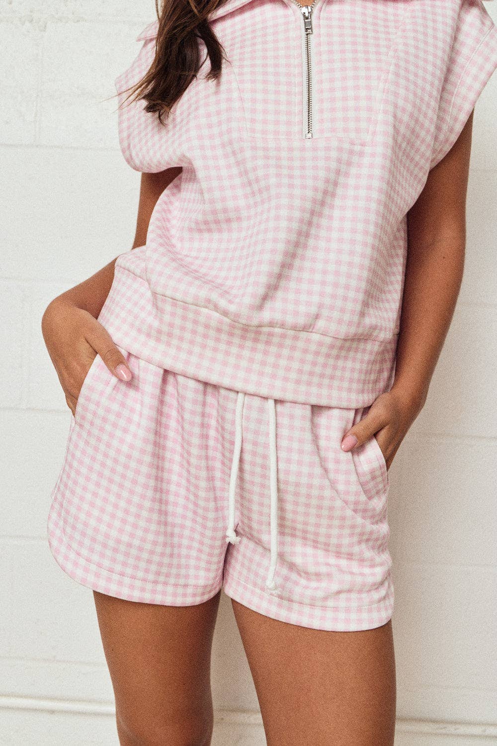 Person wearing a pink checkered outfit against a white background