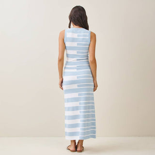 Woman wearing a long blue and white striped dress on a plain background