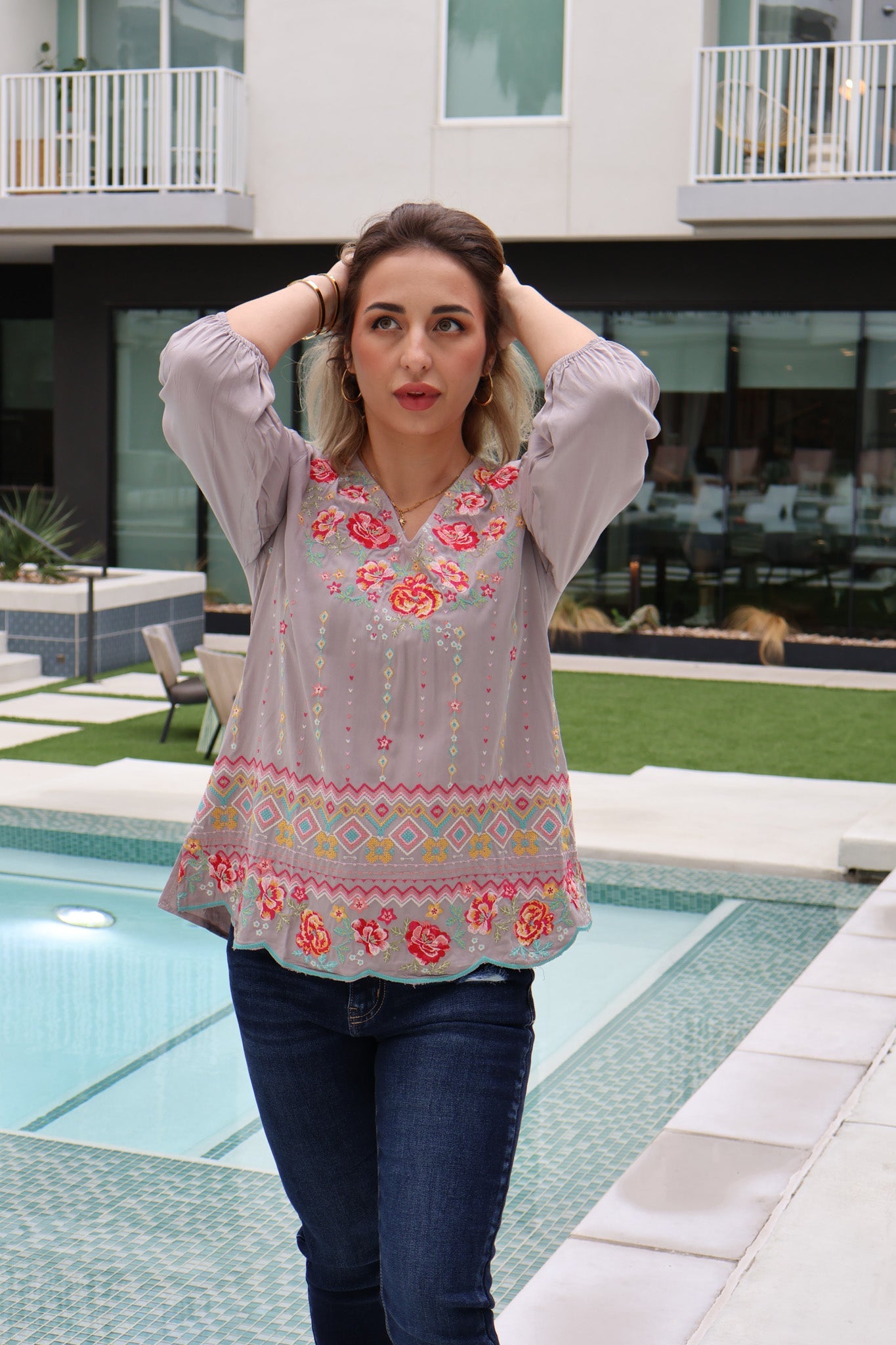 Woman wearing a floral blouse by a poolside