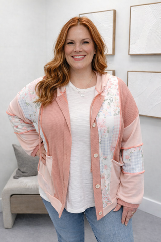 Woman wearing a pink cardigan with floral patterns indoors