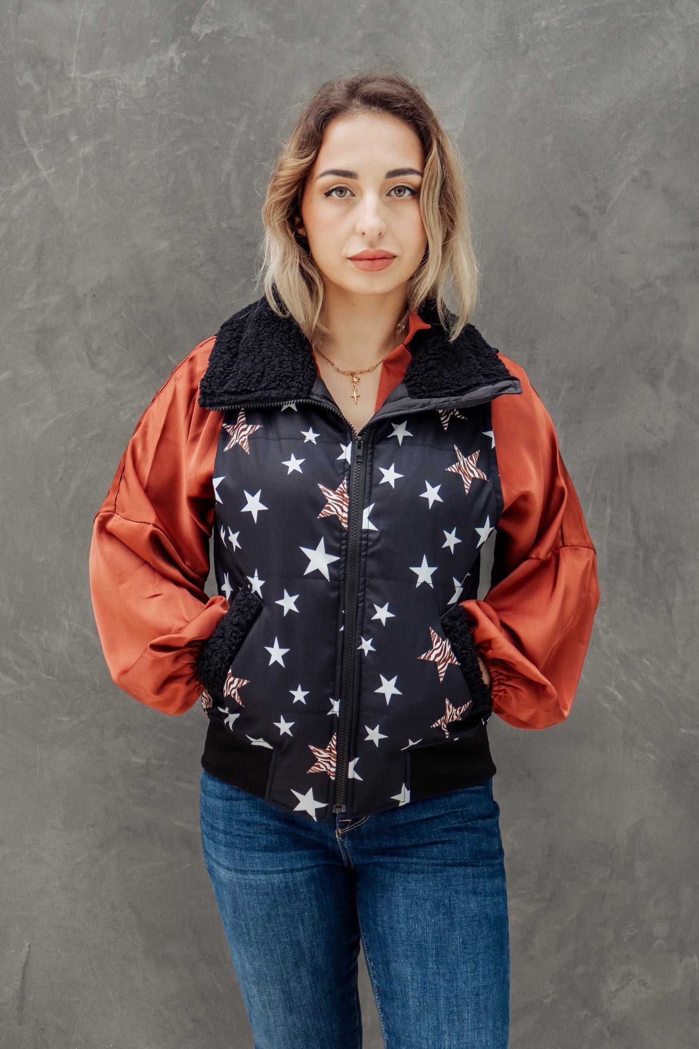 Woman wearing a jacket with star pattern against a gray background