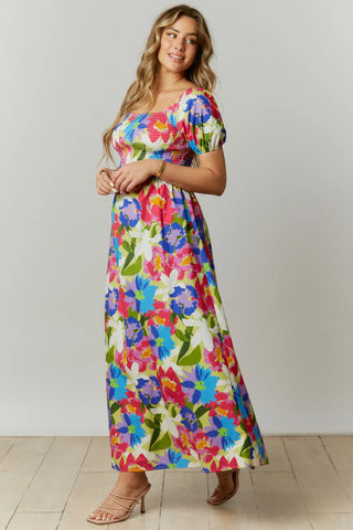 This abstract floral print maxi dress features a cut-out back with a square neckline and short puff sleeves.  The dress is composed with a smocked bodice.