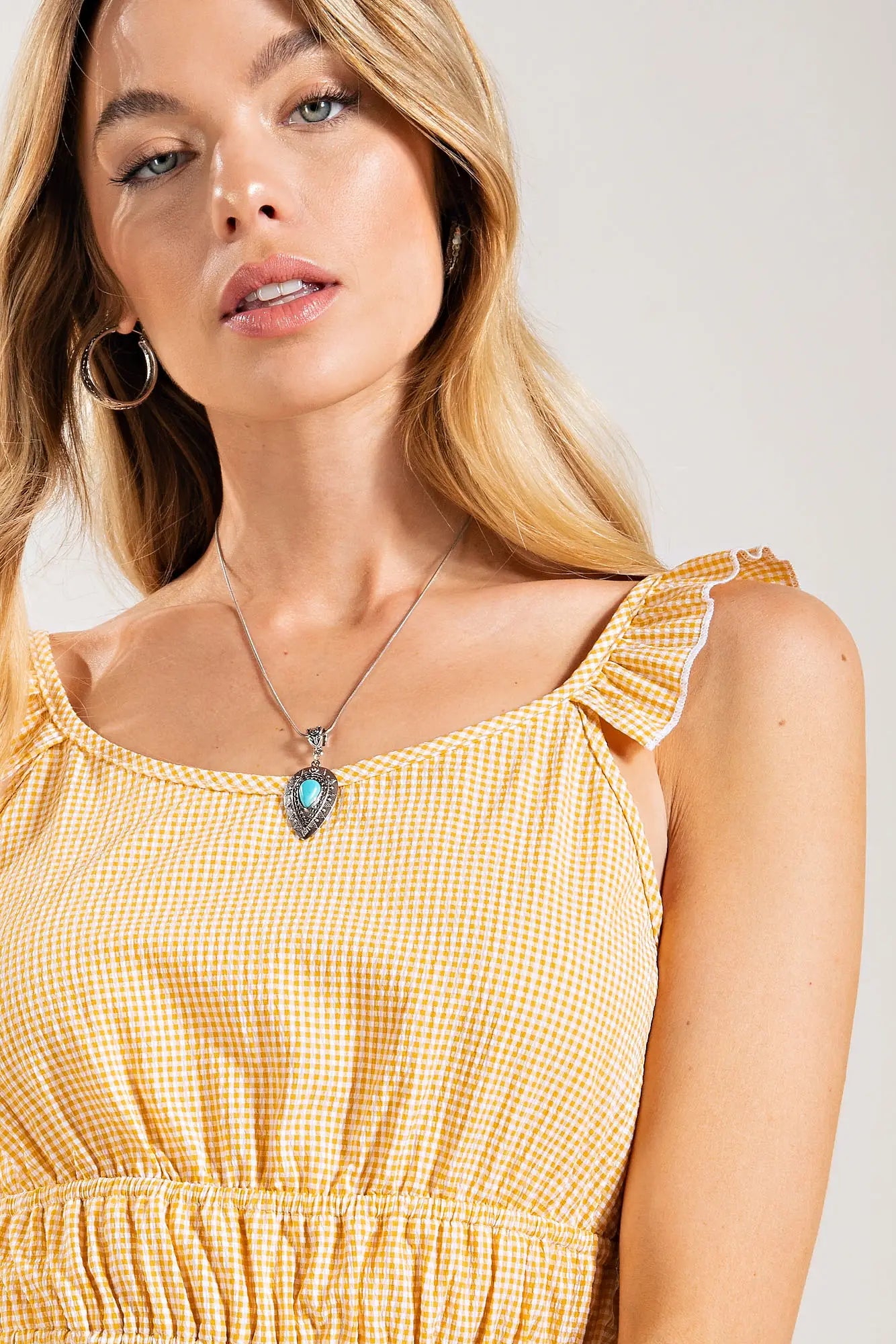 This unique plus size, Seersucker, micro gingham blouse features a ruffled detail on shoulder. It has a ruched waistline that has a tiered hem. The top is woven. Warm days in San Luis Obispo will not be a problem.